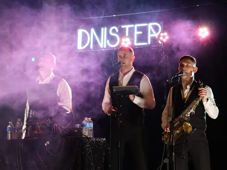 The band on stage at Dnister under the DNISTER sign